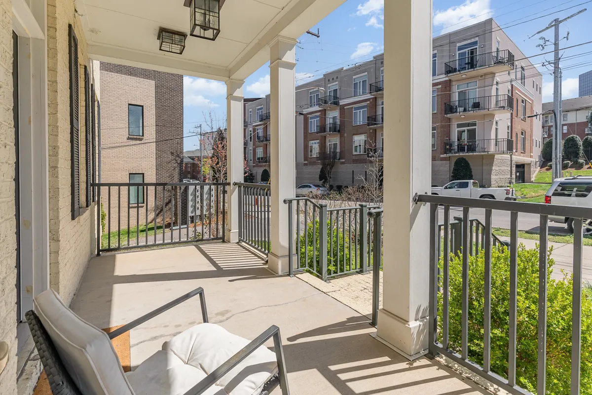 A tranquil porch scene featuring comfortable seating, sturdy railings, and a beautifully landscaped garden. The arrangement invites guests to sit, relax, and enjoy moments of peace while soaking in the outdoor ambiance.