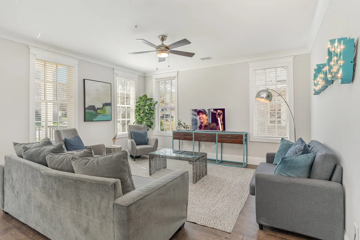 A cozy living room with a sofa, coffee table, television, potted plant, and wall art, arranged for comfort and socializing—ideal for relaxing after exploring the city.
