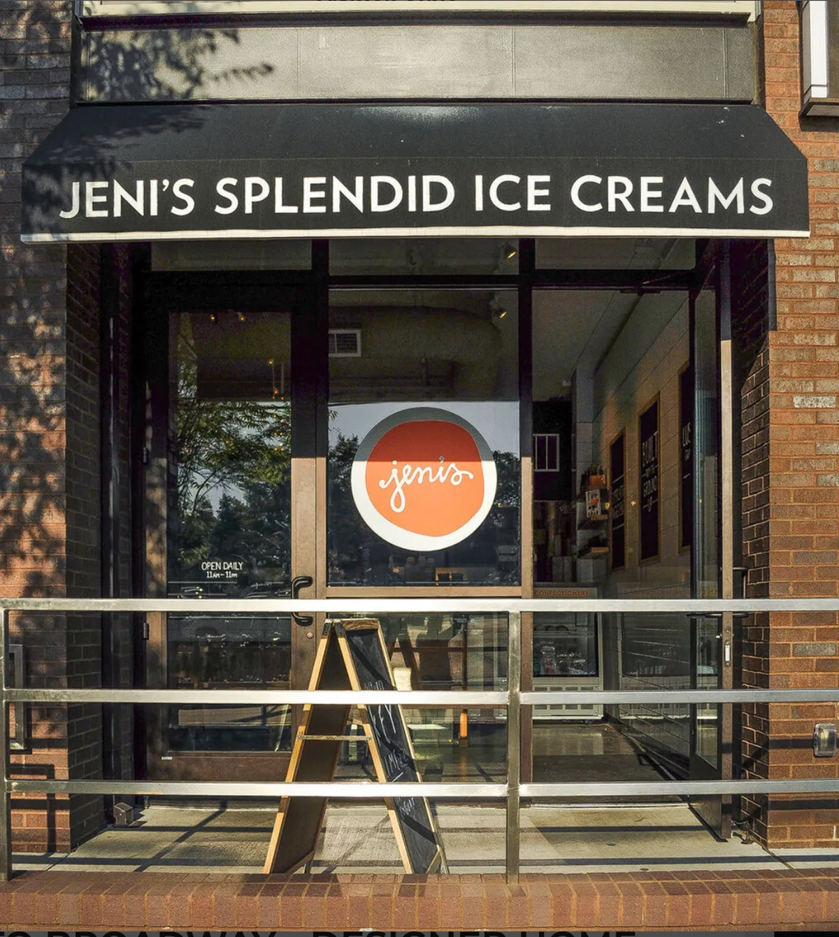 A cheerful storefront is visible, with signage and a menu board suggesting a welcoming spot to stop for ice cream. People are gathered outside, socializing and enjoying treats, creating a sense of community and fun.